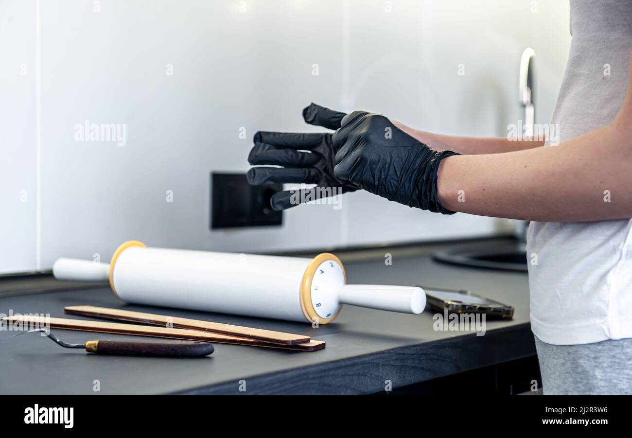 A woman puts on gloves in the kitchen, kitchen work and hygiene Stock Photo Alamy