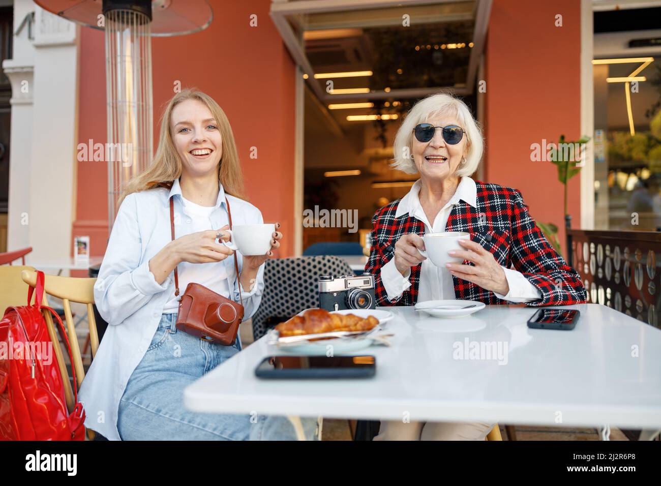Two happy women having coffee at sidewalk cafe Stock Photo