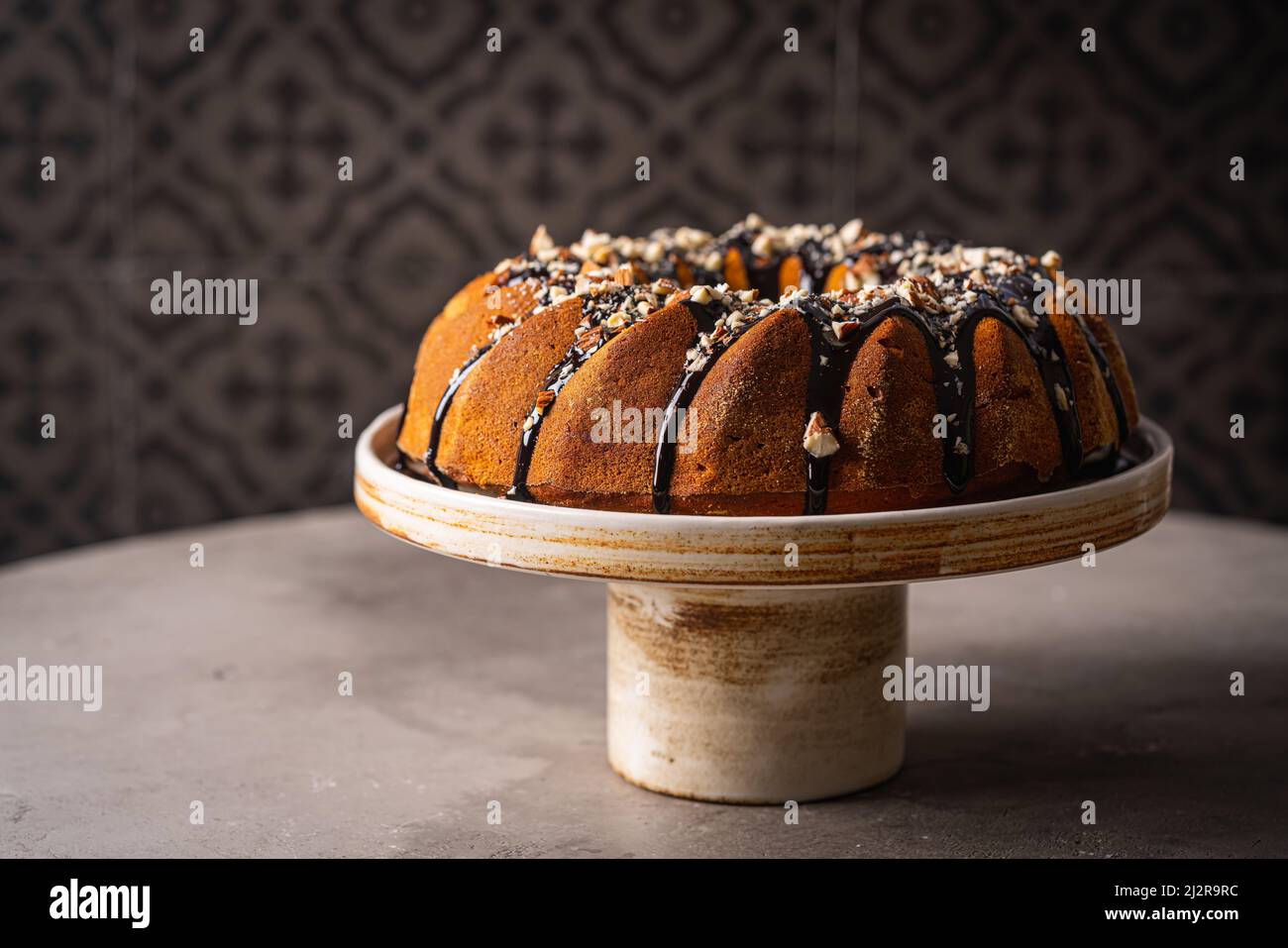 Vanilla bundt cake with chocolate glaze and nuts on top Stock Photo Alamy