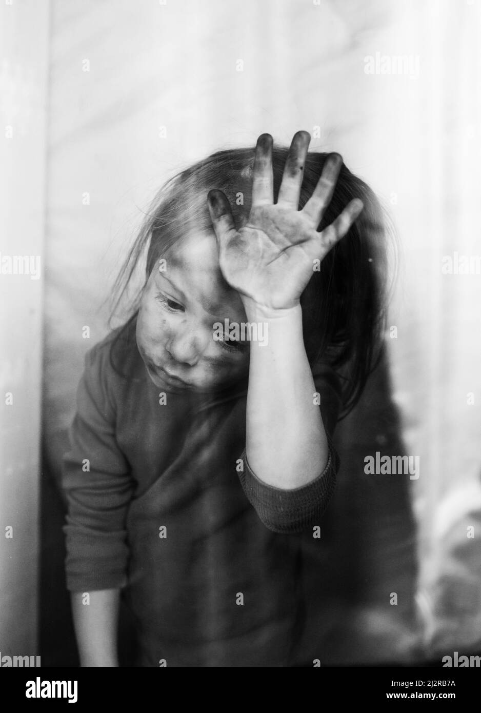 a little Ukrainian girl with a face blackened by fire is standing