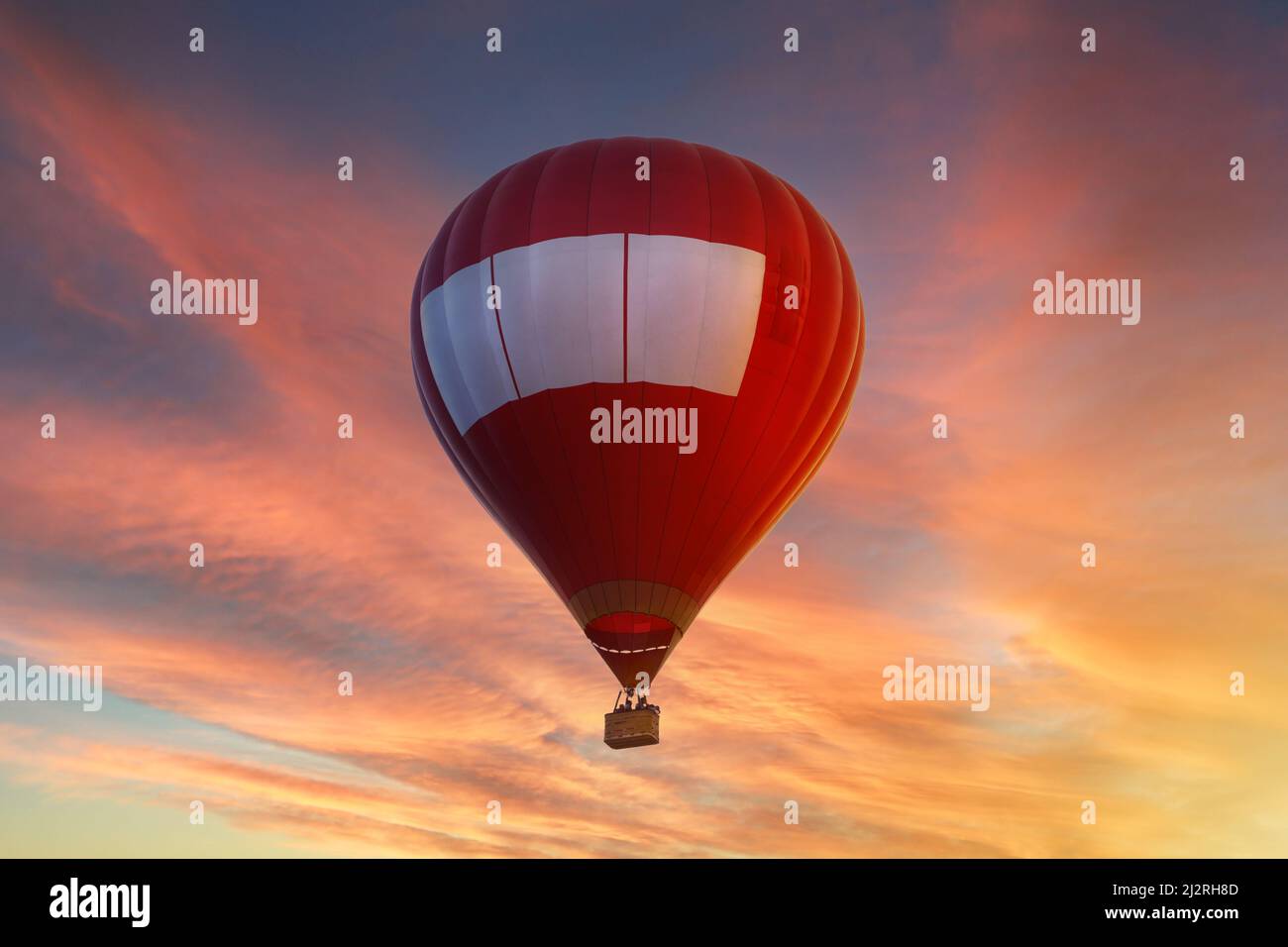 Red hot air balloon flying in the sky at sunset or sunrise Stock Photo ...