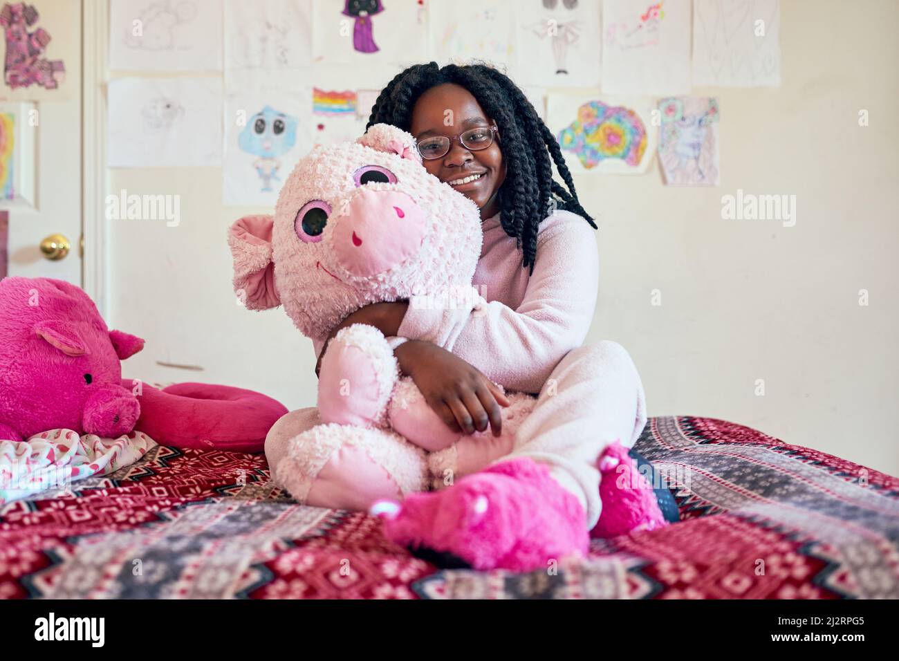 I cant sleep without my best friend. Portrait of an adorable little girl holding a plush toy while sitting on her bed in her bedroom. Stock Photo