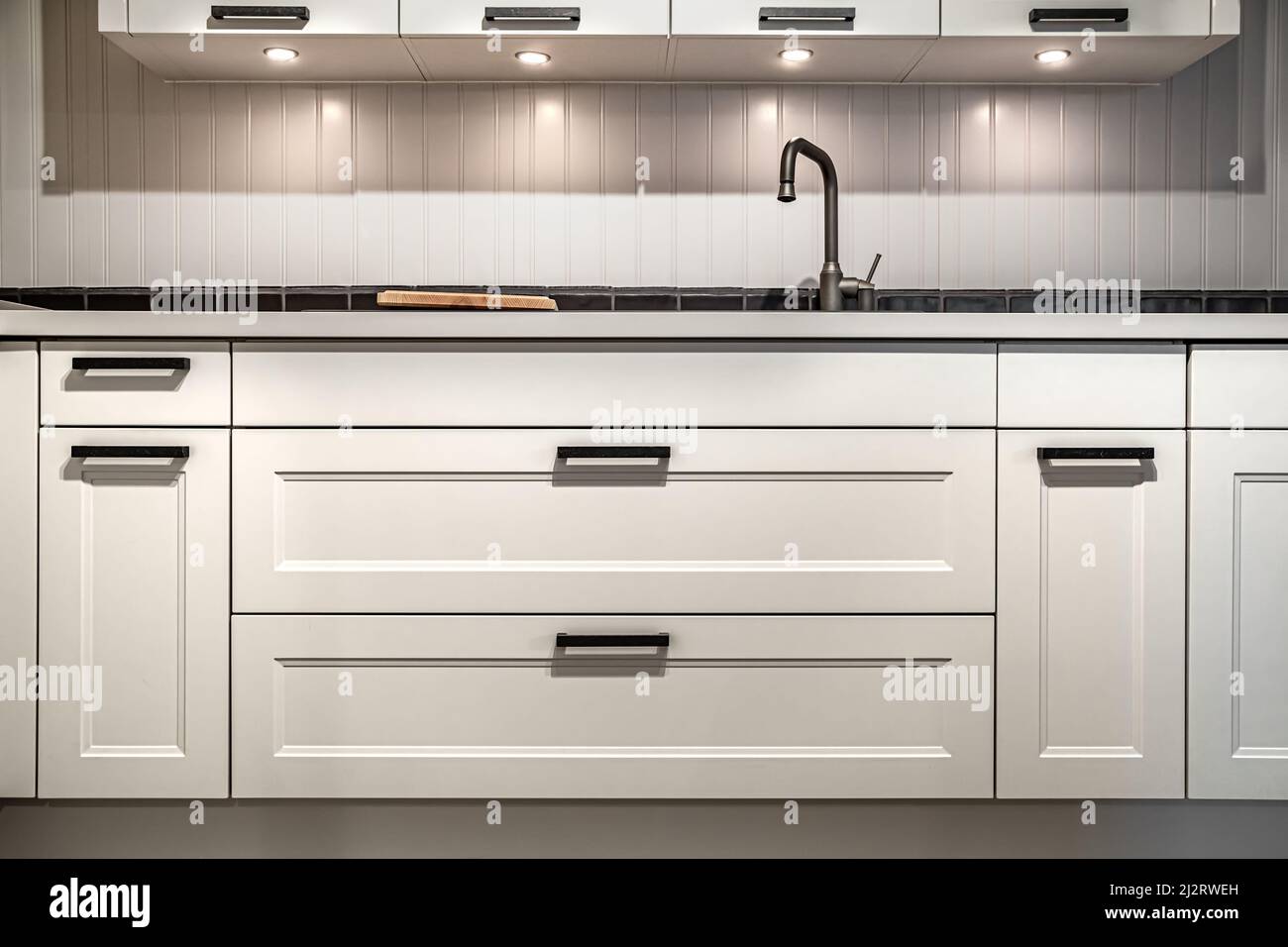 White kitchen cabinets with metal pulls or knobs on the doors Stock ...