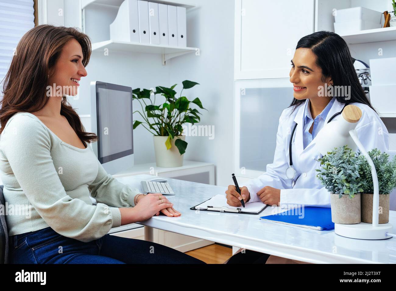 Young lady client patient visiting pleasant attentive female doctor physician at modern clinic medical center healthcare industry Stock Photo