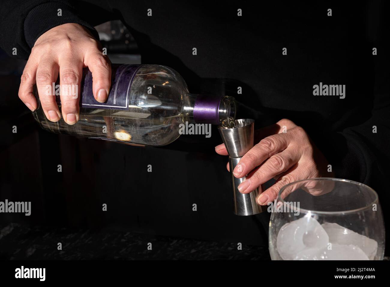 PREPARING COCKTAIL. MEASURING QUANTITY OF ALCOHOLIC BEVERAGE. Stock Photo