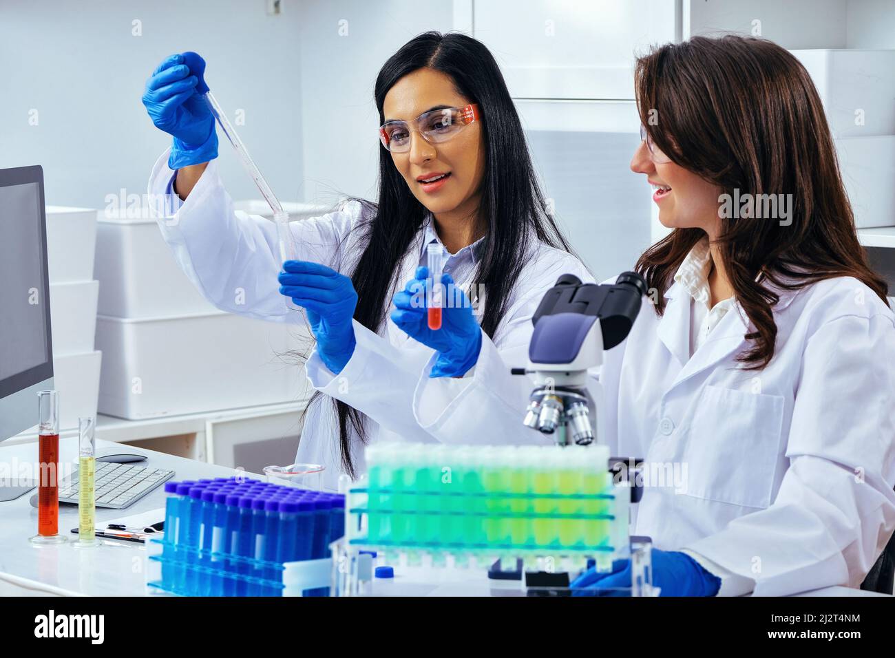 Two beautiful young female scientists working in laboratory with test tubes doing some research pharmaceutical Stock Photo