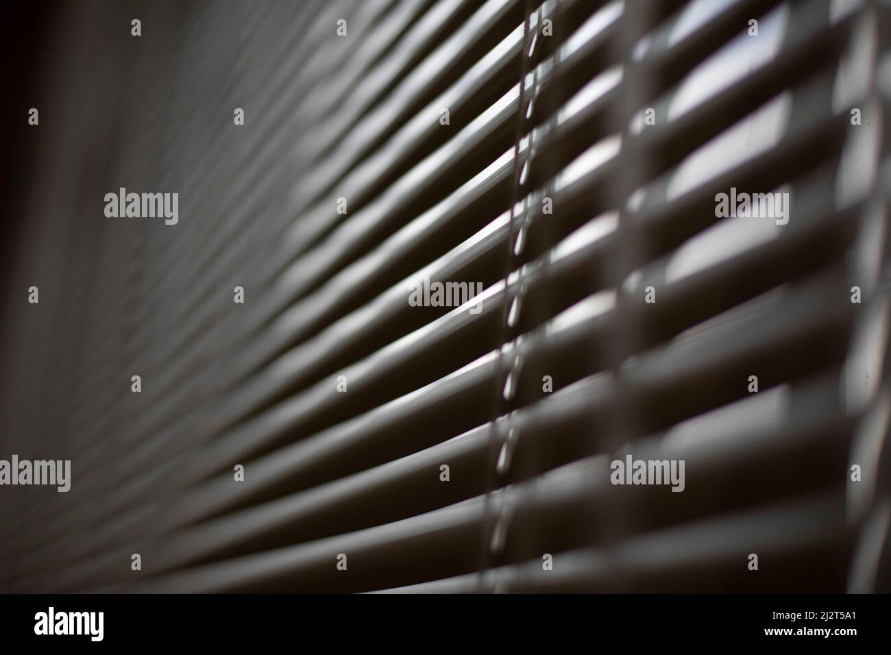 Blinds on window. White blinds cover window from sun. Interior details. Shooting diagonally. Stock Photo