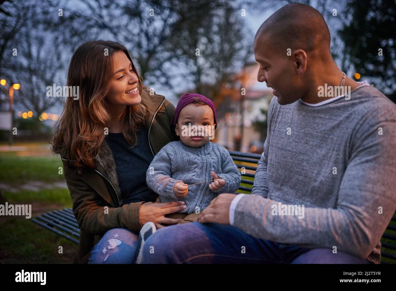 We brought our cutie to explore the park today. Shot of a mother and a father bonding with their little son outdoors. Stock Photo