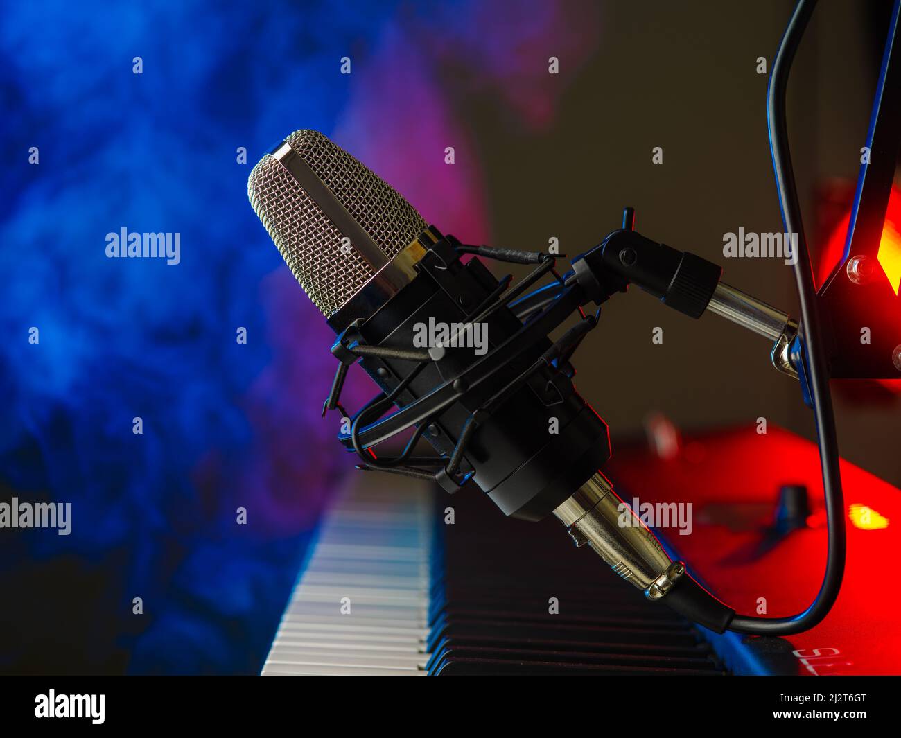 Midi keyboard, synthesizer and microphone on a multicolored background