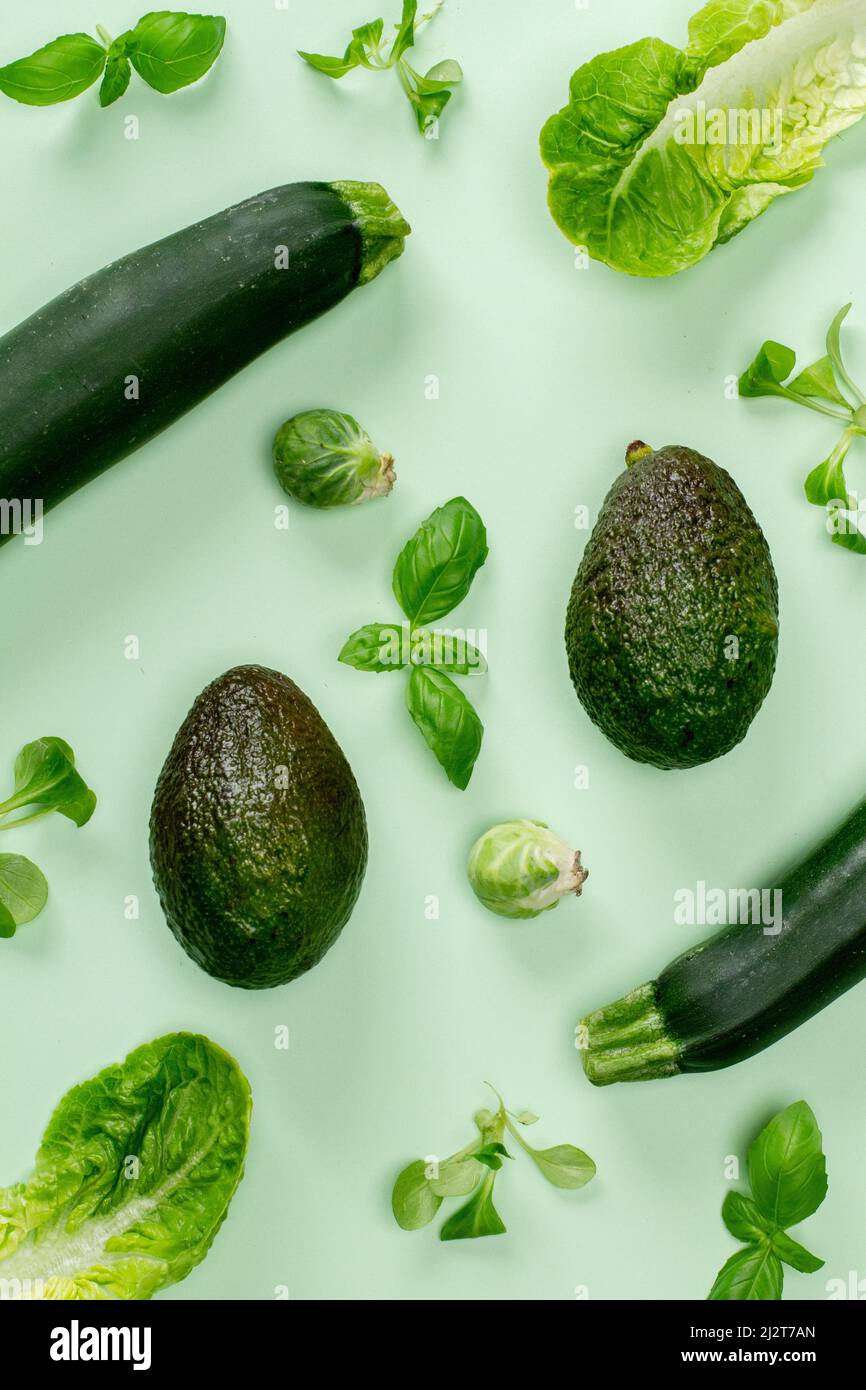 Flat lay top view green color vegetable isolated on a mint pastel background with a soft shadow. Horizontal orientation Stock Photo