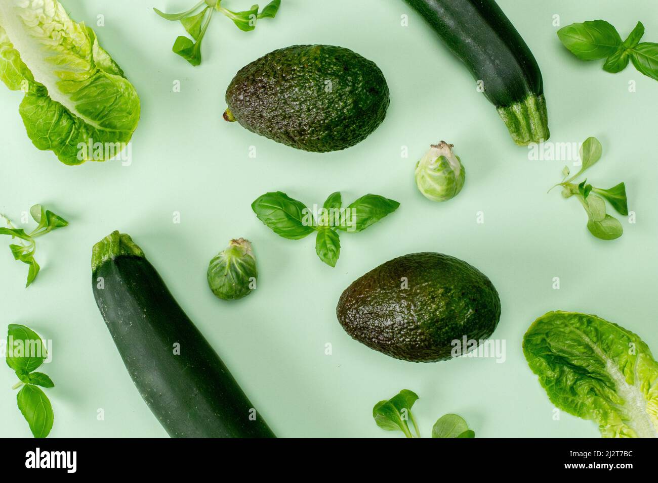 Flat lay top view green color vegetable isolated on a mint pastel background with a soft shadow. Horizontal orientation Stock Photo