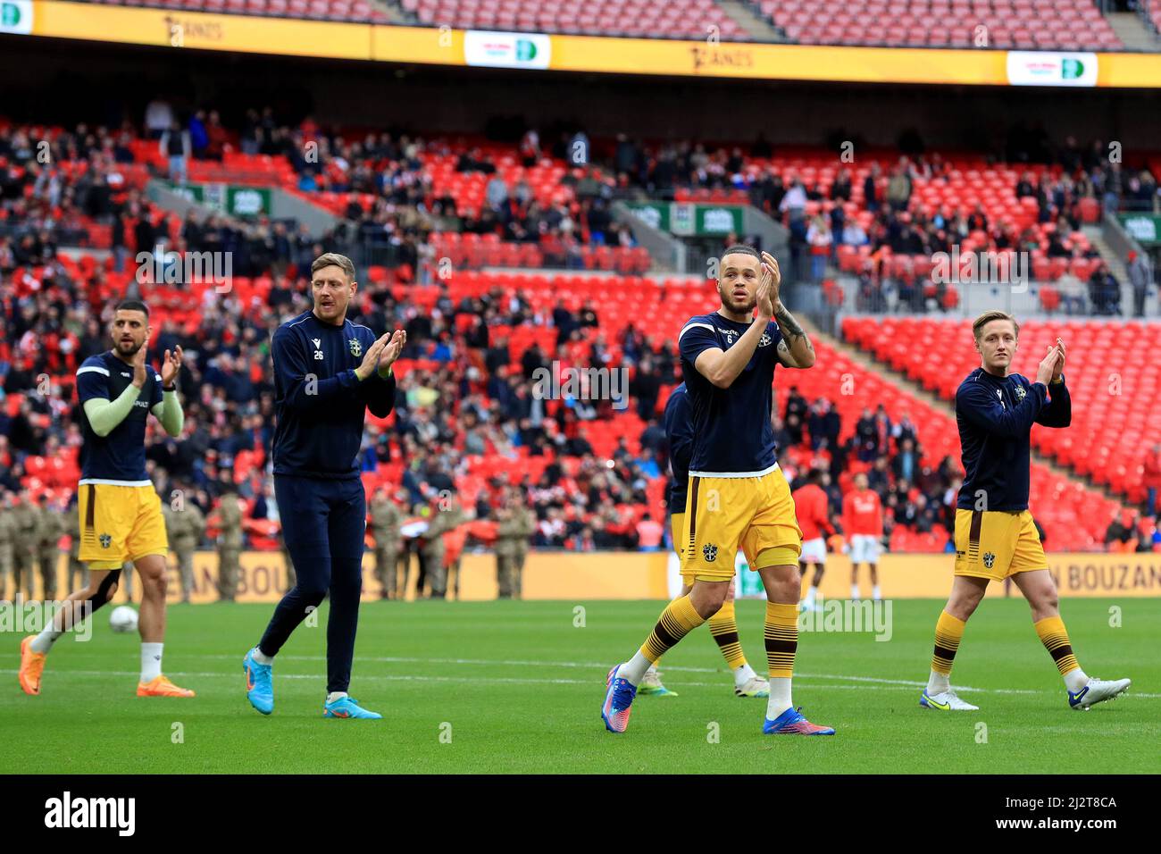 (L-R) , Omar Bugiel, Richard Bennett, Louis John and Ben Wyatt #3 of Sutton United applaud fans. Stock Photo