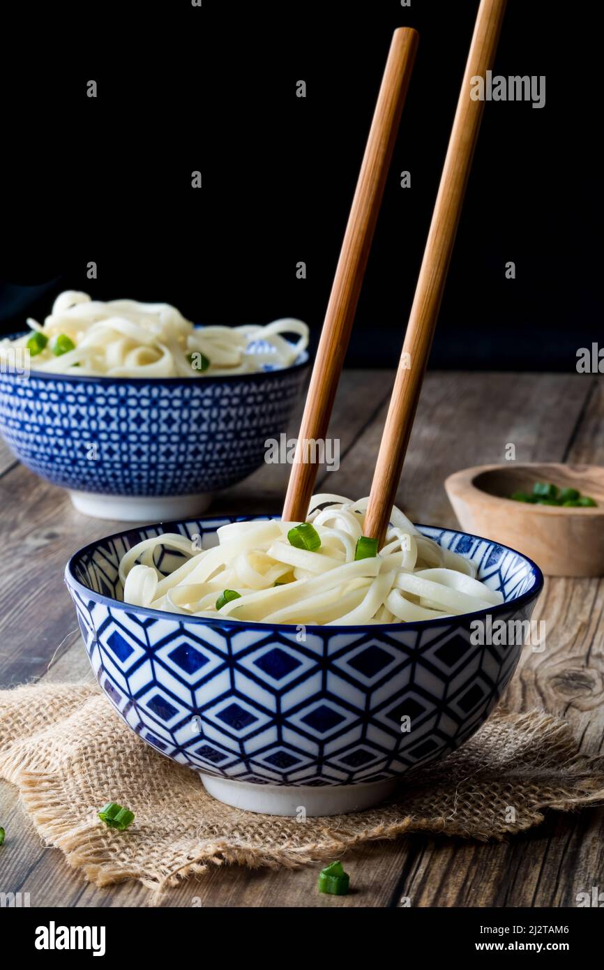 A decorative bowl filled with noodles and chopsticks sticking out. Stock Photo