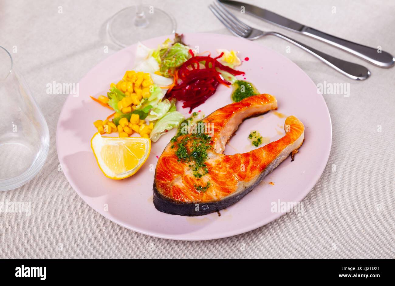 Baked salmon steak with green sauce, lemon and vegetables Stock Photo Alamy