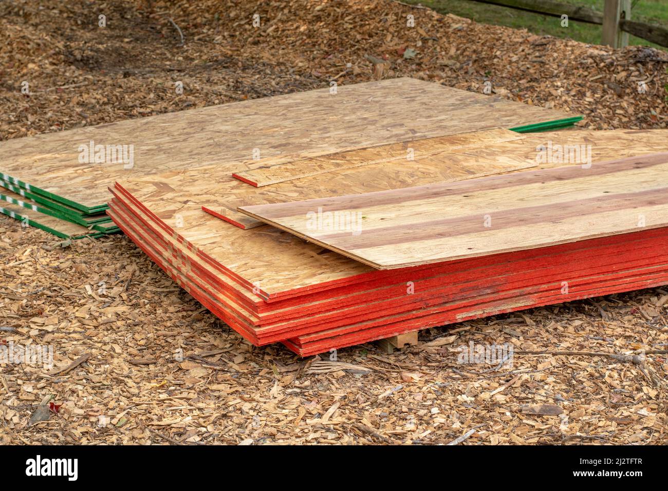 piles of sheeting are set on pallets at a job site of a new home addition Stock Photo