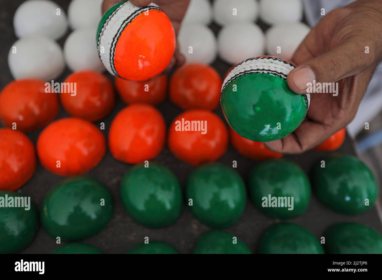 Meerut, India. 29th June, 2019. A worker holds finished cricket balls
