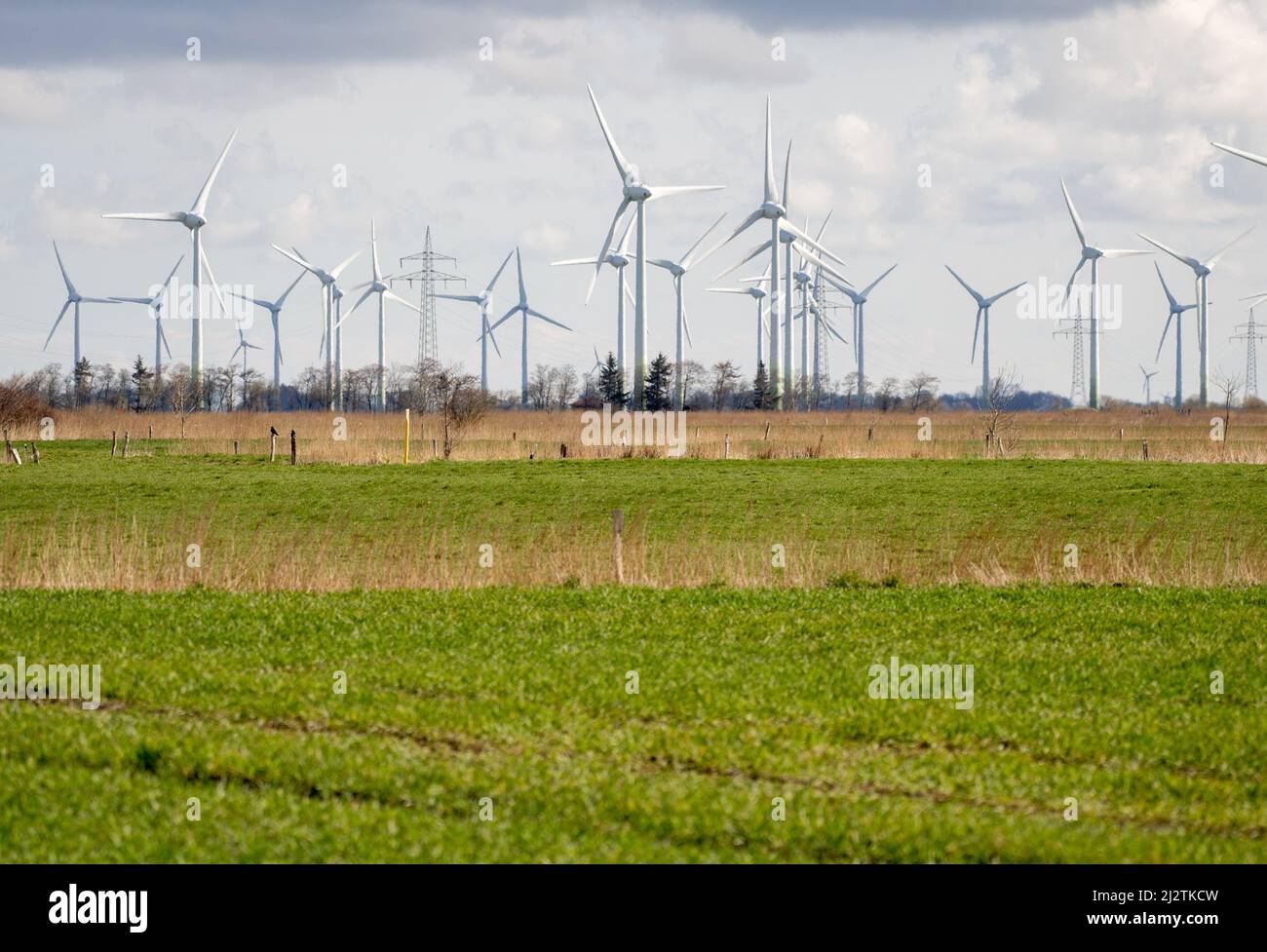 Norden, Germany. 02nd Apr, 2022. Numerous wind turbines are located on fields in the district of Aurich. The Intergovernmental Panel on Climate Change (IPCC) will present the third part of its new assessment report on April 4, 2022. It deals with the political and technological measures to mitigate climate change. Credit: Hauke-Christian Dittrich/dpa/Alamy Live News Stock Photo