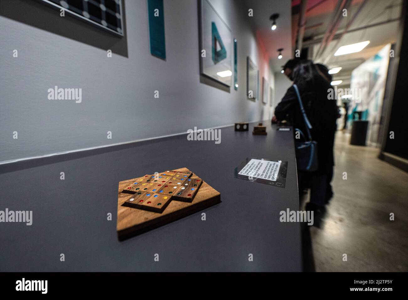 People play with interactive wooden blocks at a museum. Visitors view ...