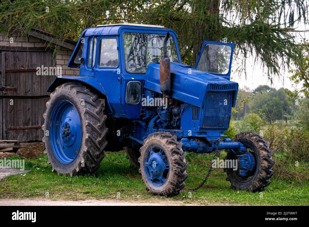 Old vintage blue tractor in the countryside. Stock Photo