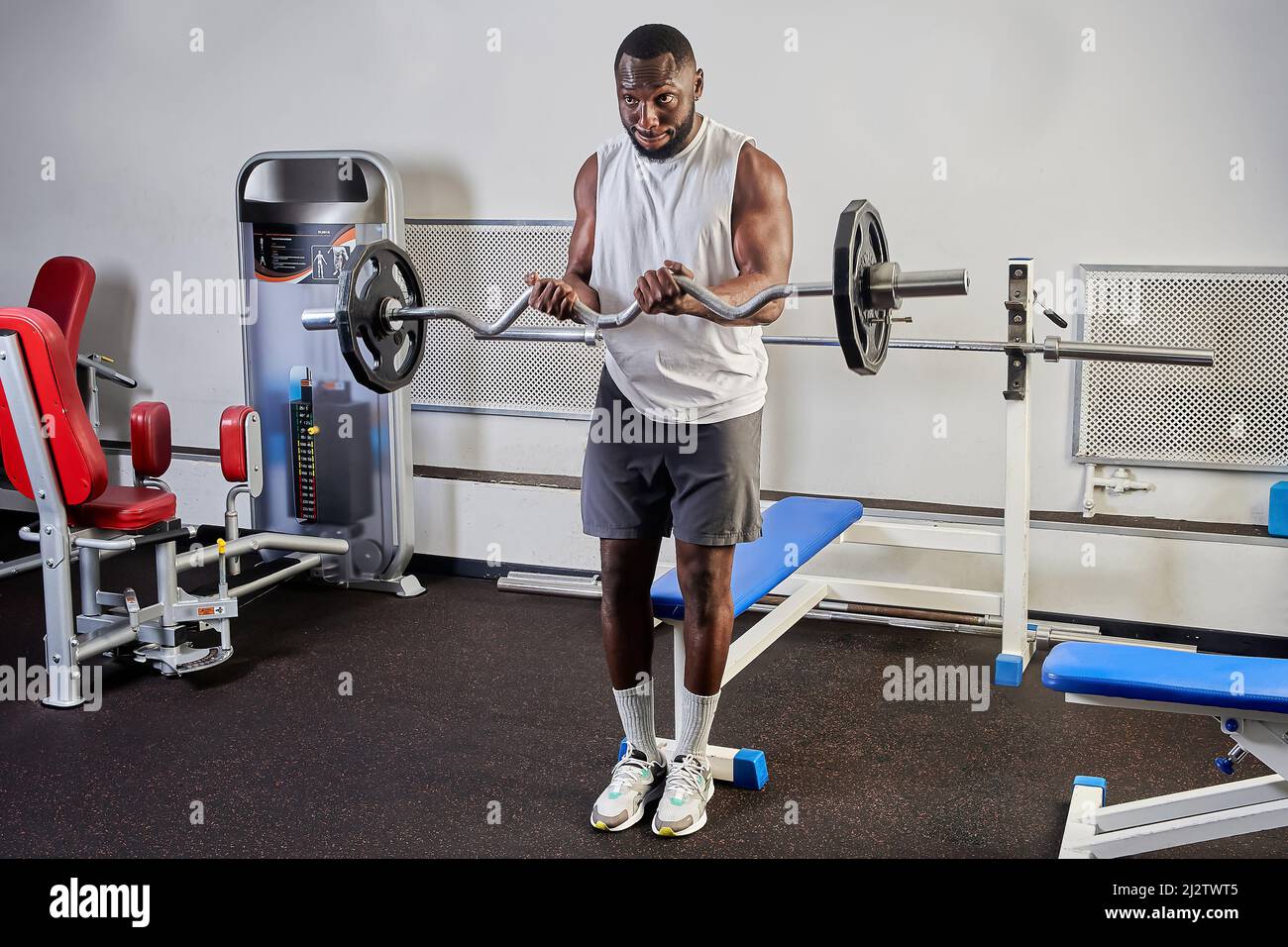 AfricanAmerican man shakes biceps in the gym Stock Photo Alamy