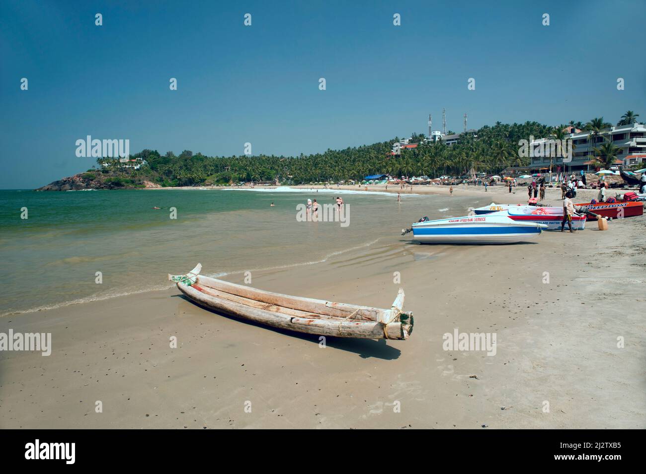 Traditional fishing boat and modern boats parked on Kollam beach state ...