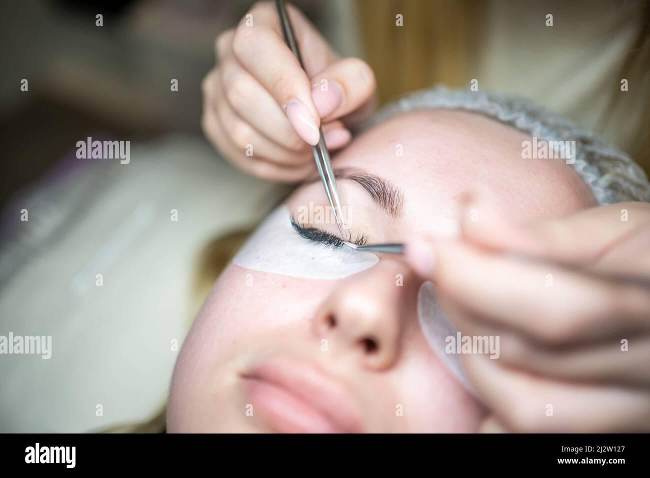 Eyelash extension procedure in beauty salon. Lashes close up. Concept spa lash.  Stock Photo