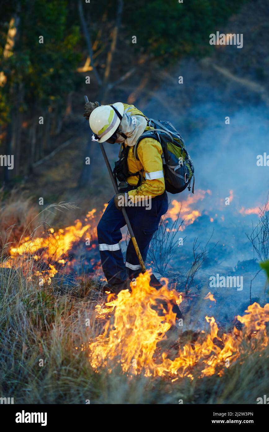 Everyday heroism. Shot of fire fighters combating a wild fire. Stock Photo