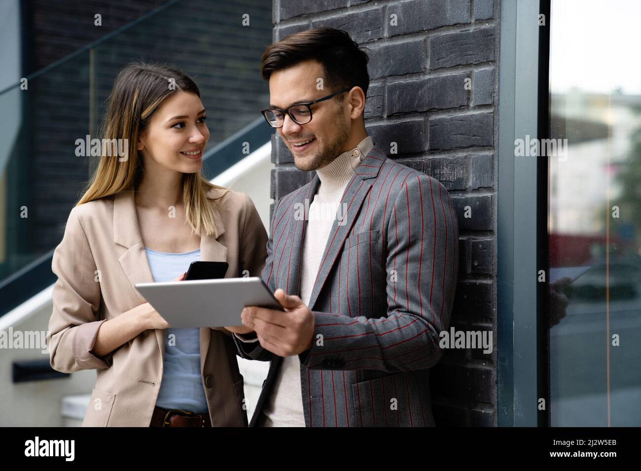 Portrait of successful business people working, talking together in urban background. Stock Photo