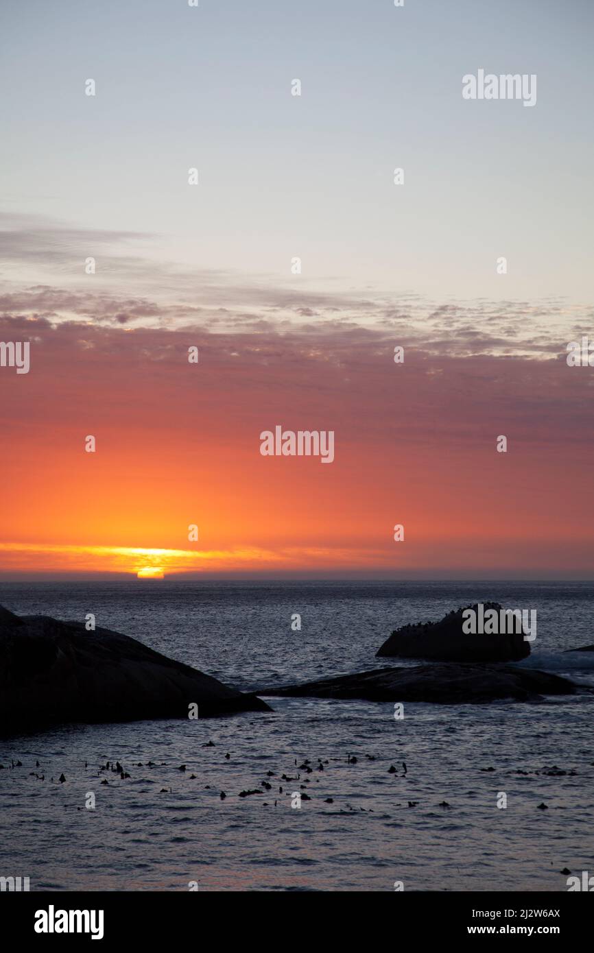 Sunset over Sea with Boulder Stock Photo