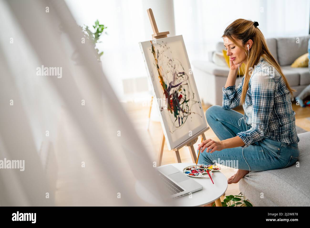 Art, creativity, hobby, job and creative occupation concept. Woman painting at home. Stock Photo