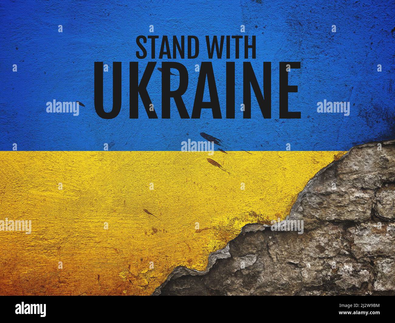 Stand with Ukraine message on worn old brick wall painted in colors of Ukrainian flag, copy space included Stock Photo