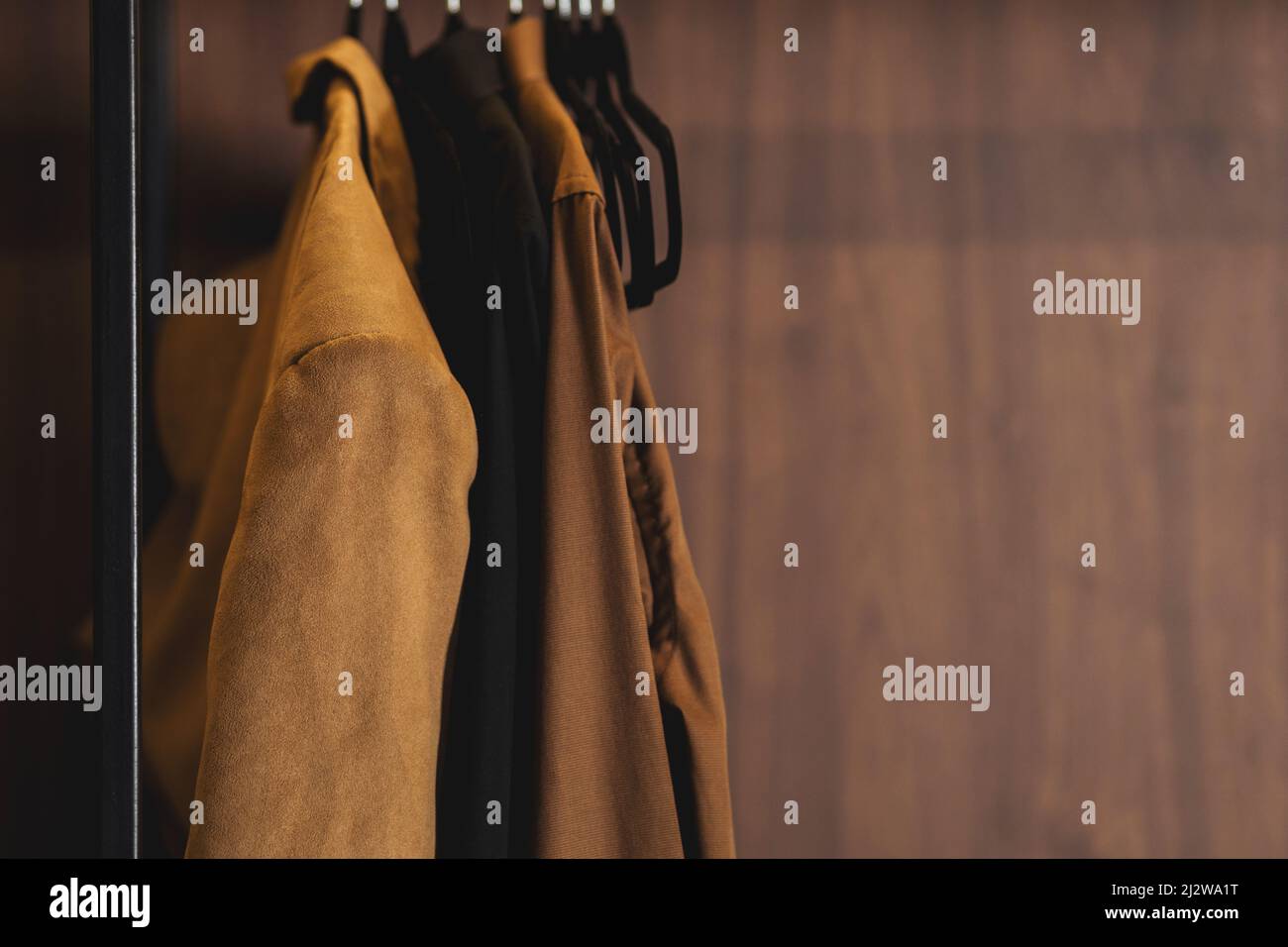 Row of men's suits hanging in closet. menswear store. Stock Photo