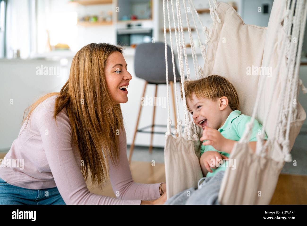 Happy little toddler boy having fun with his mother at home. Single parenting, happiness concept. Stock Photo