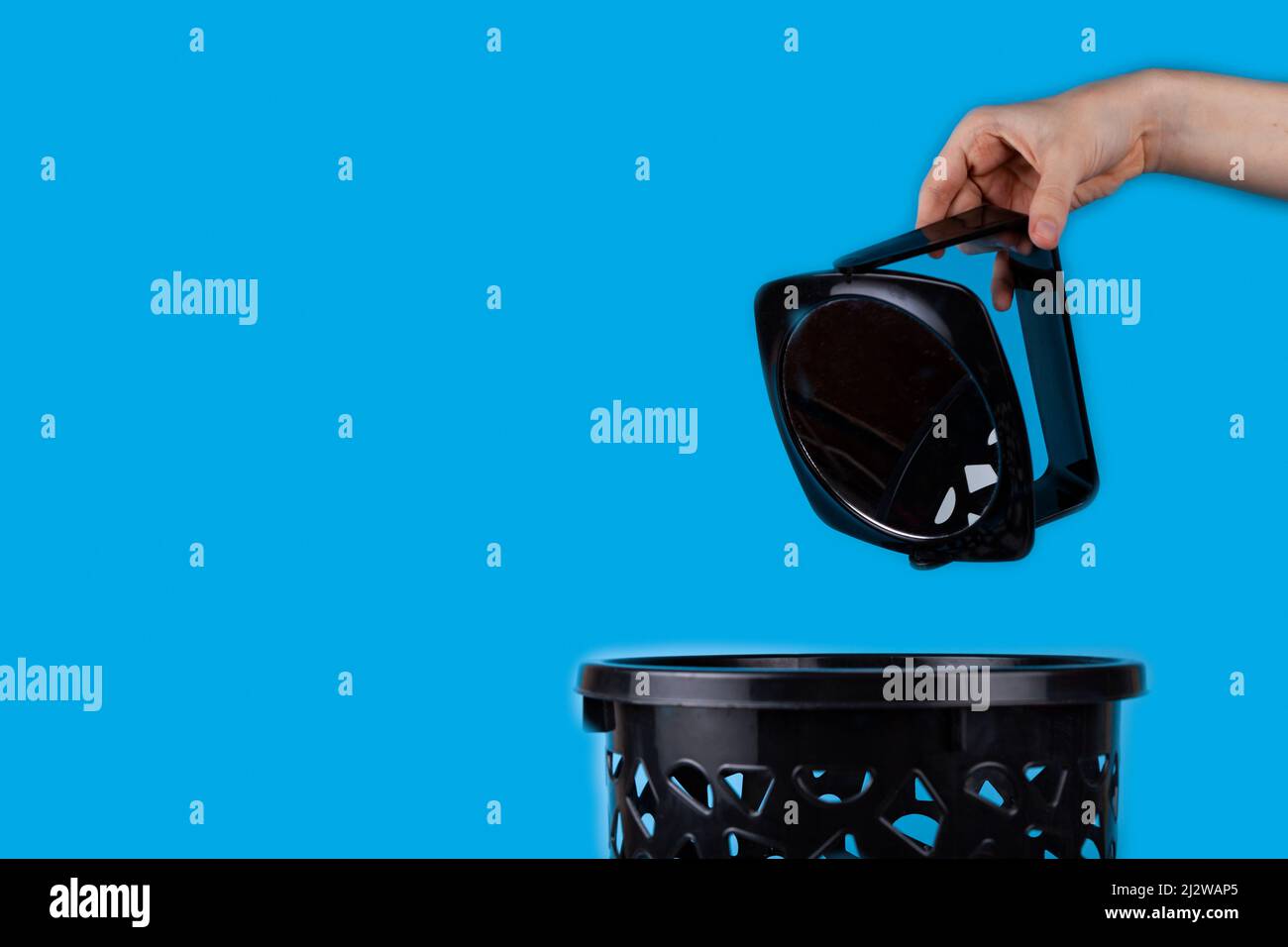 The mirror is thrown into the trash can. Blue background, place for text Stock Photo Alamy