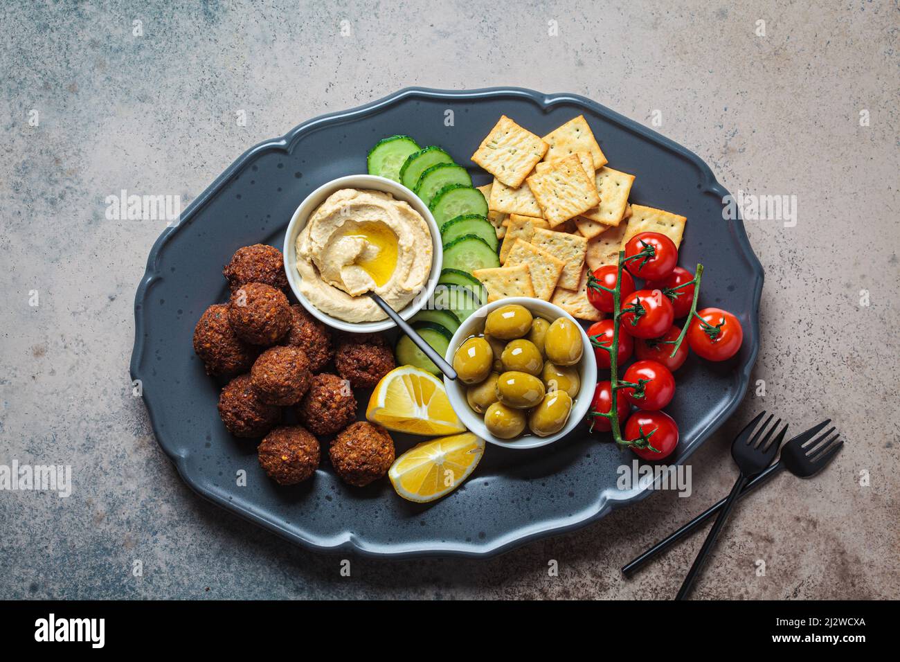 Falafel platter with hummus, olives, crackers and vegetables, top view