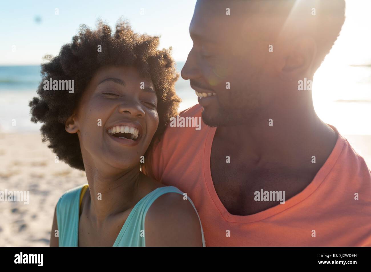 Happy african american couple enjoying summer holiday together at beach on sunny day Stock Photo