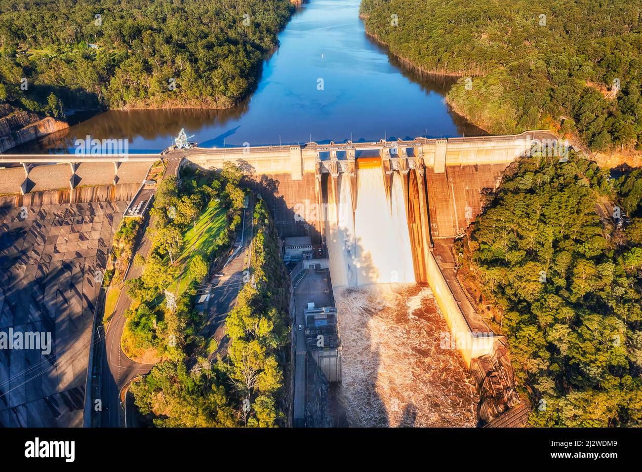 Spilling over the Warragamba dam leaking water in Blue Mountains of Australia during floods - aerial view. Stock Photo