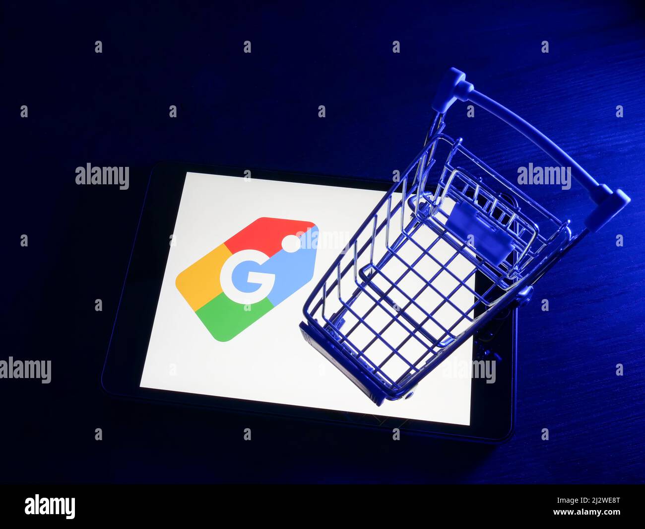 KYIV, UKRAINE - March 30, 2022. Google shopping logo on the screen and shopping cart. Stock Photo