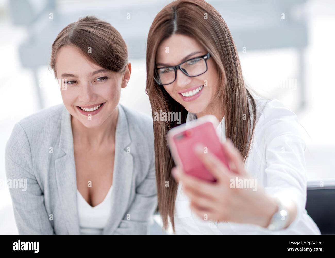 two business women taking selfies in the office Stock Photo - Alamy