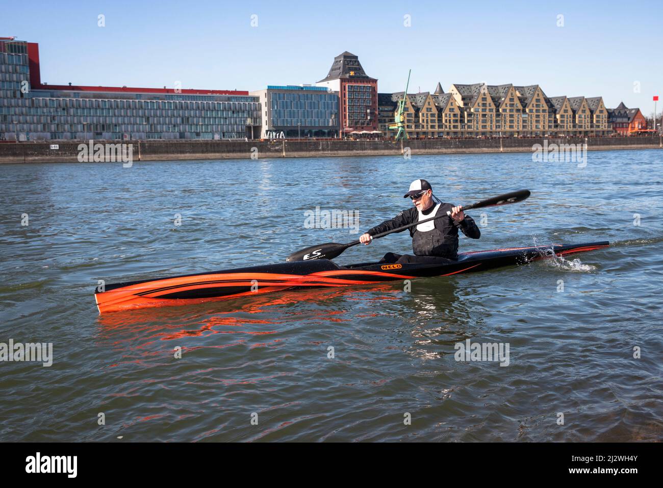 Surfski kayaker on the river Rhine, the Rheinau harbor, Cologne, Germany. Surfski Kajakfahrer auf dem Rhein, Rheinauhafen,  Koeln, Deutschland.  ###NO Stock Photo
