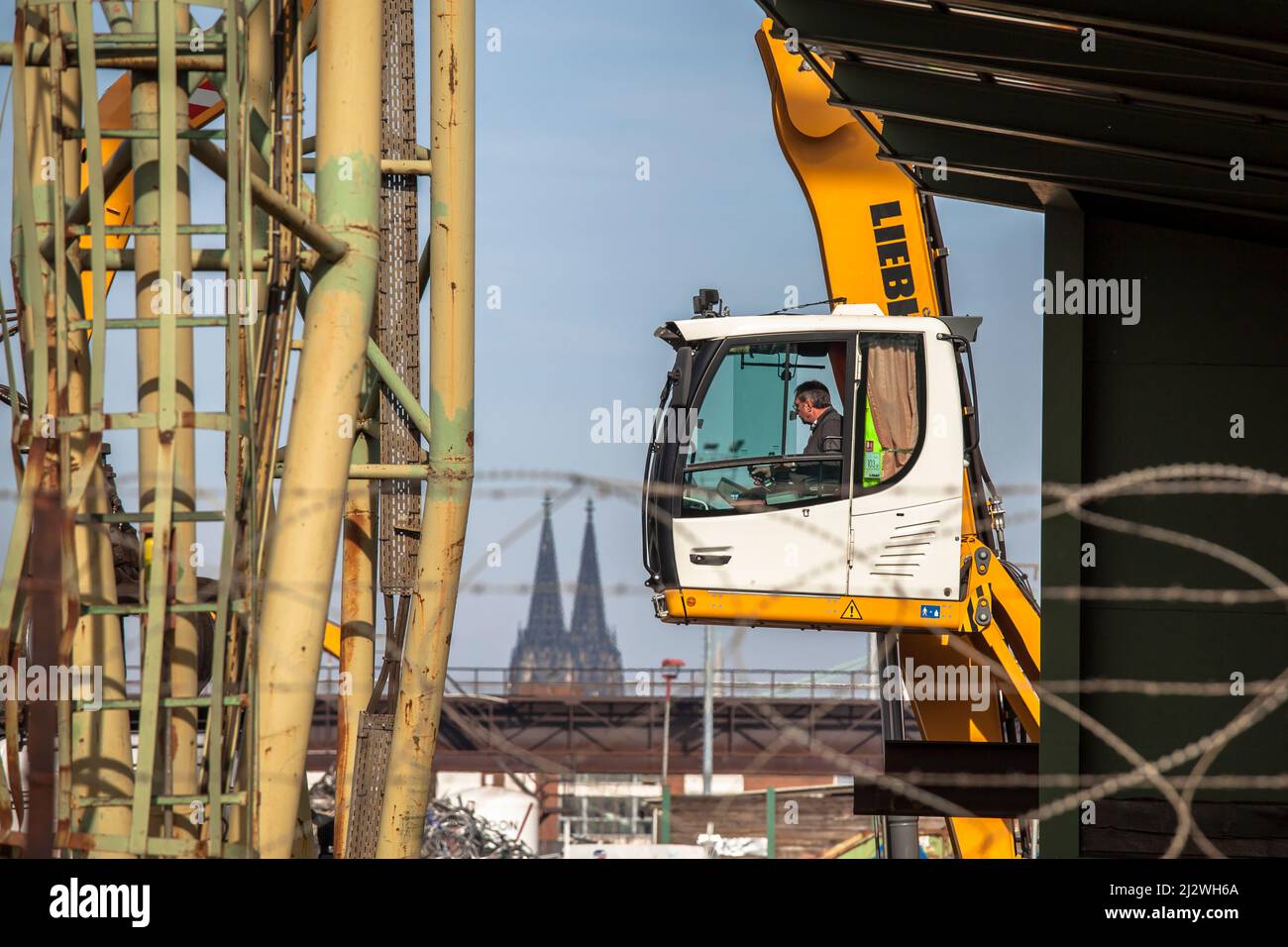 excavator operator in the Rhine harbor in the district Deutz, in the background the cathedral, Cologne, Germany. Baggerfuehrer im Hafen Deutz, im Hint Stock Photo