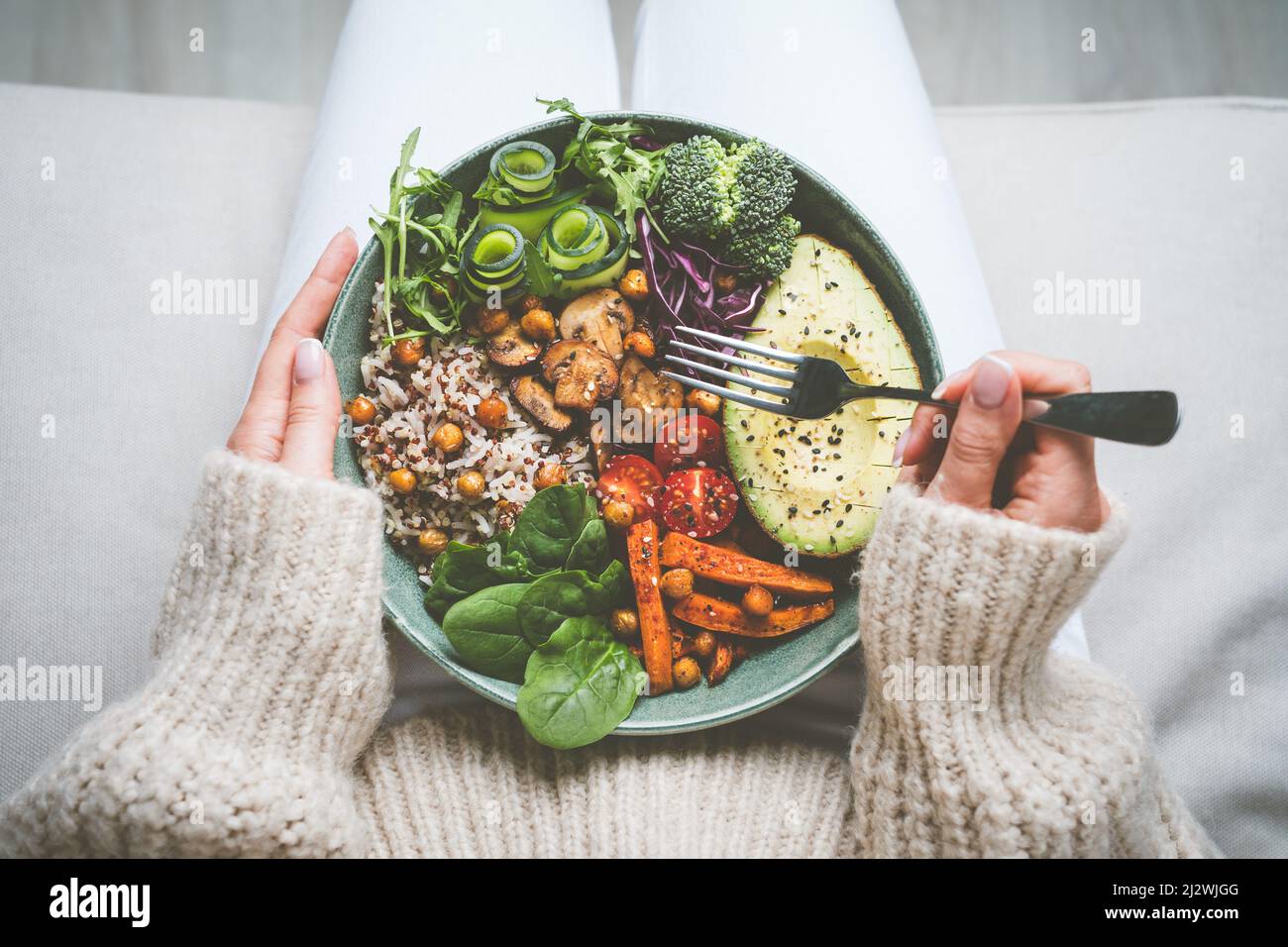 Woman holding plate with tasty vegan or vegetarian food. Healthy vegan meal. Vegan buddha bowl with healthy food. Healthy eating or diet Stock Photo