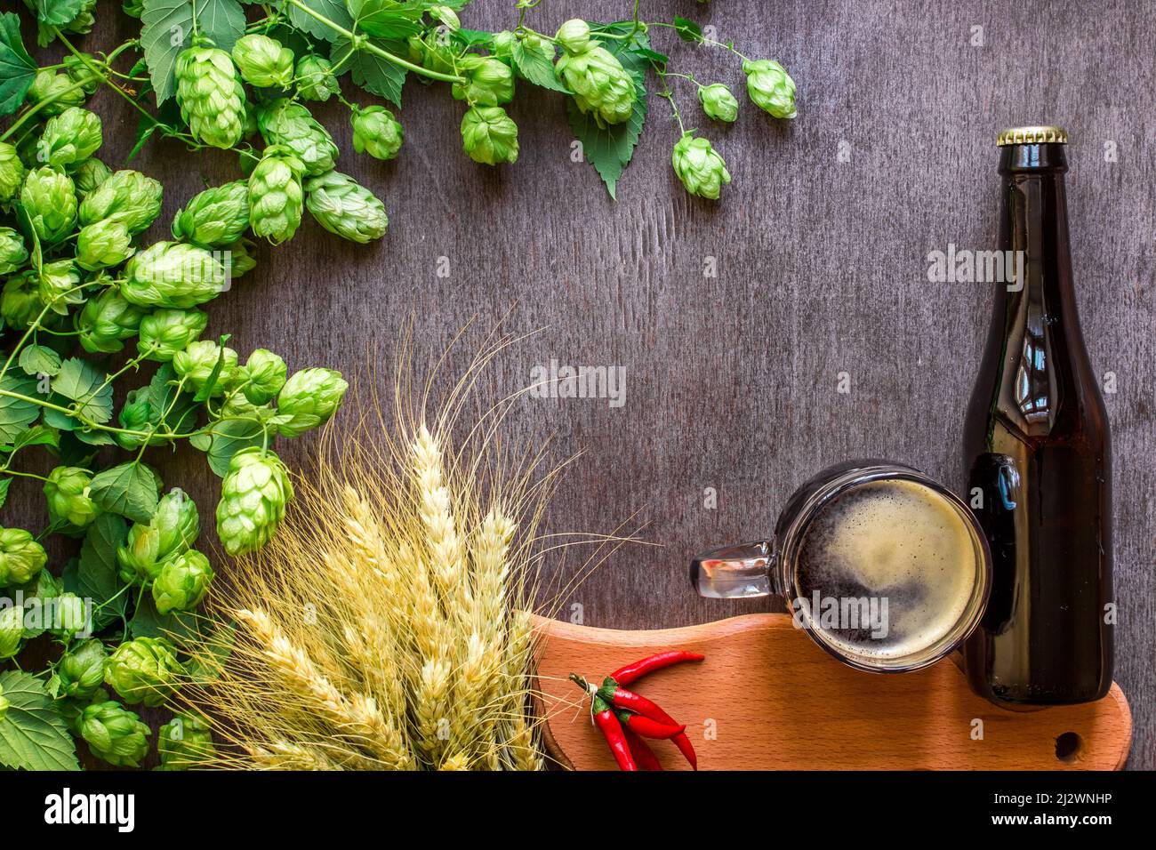 Bottle and Glass beer with Brewing ingredients. Hop flower with wheat