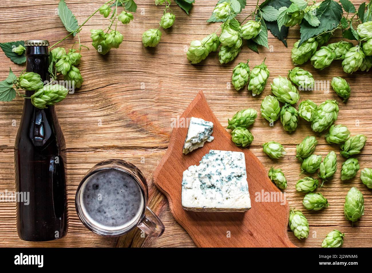 Beer background. Fresh beer and the salty cheese on a wooden table. Top view Stock Photo