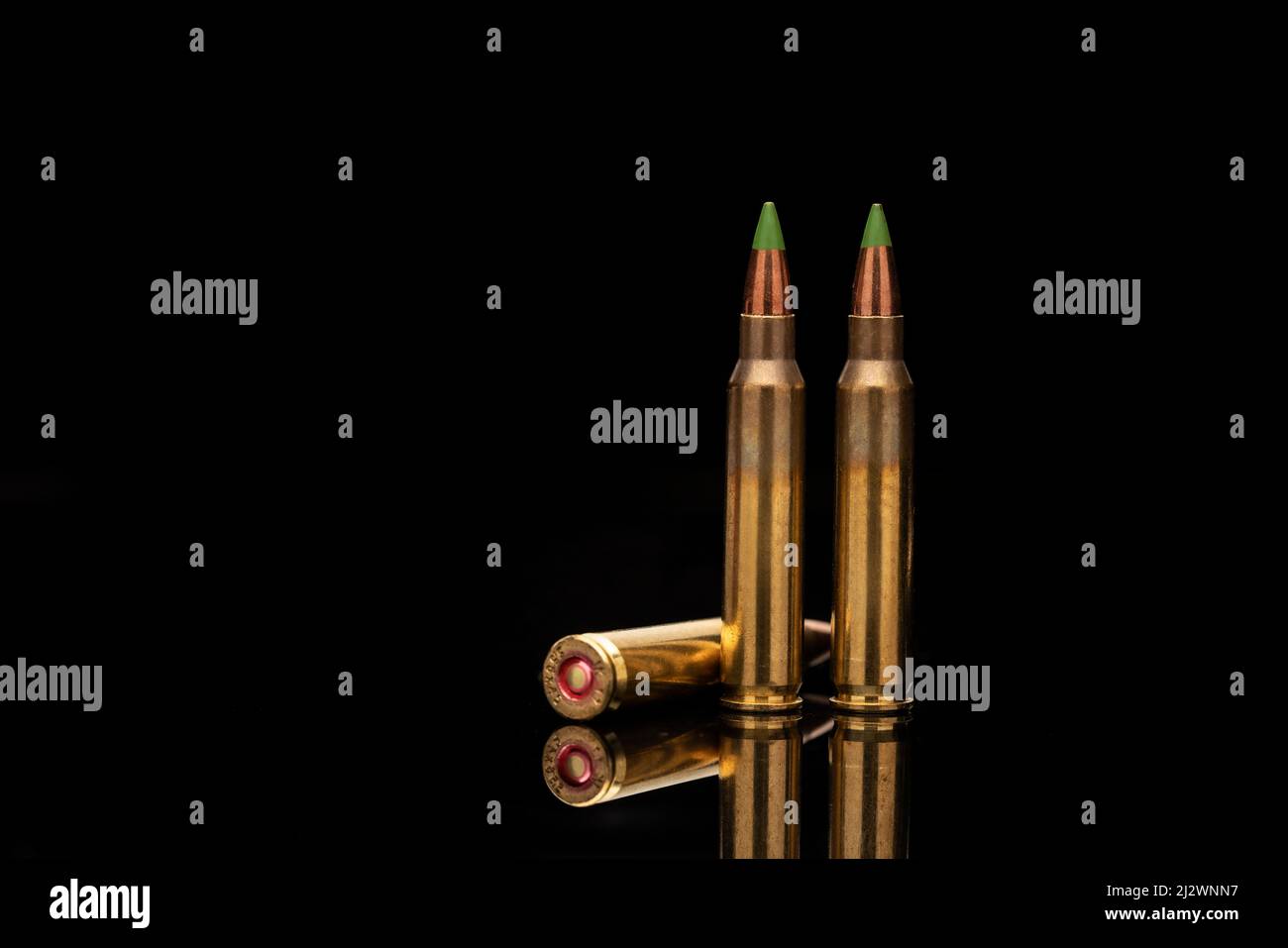 A group of 5.56 calibar, green tip bullets on black background Stock