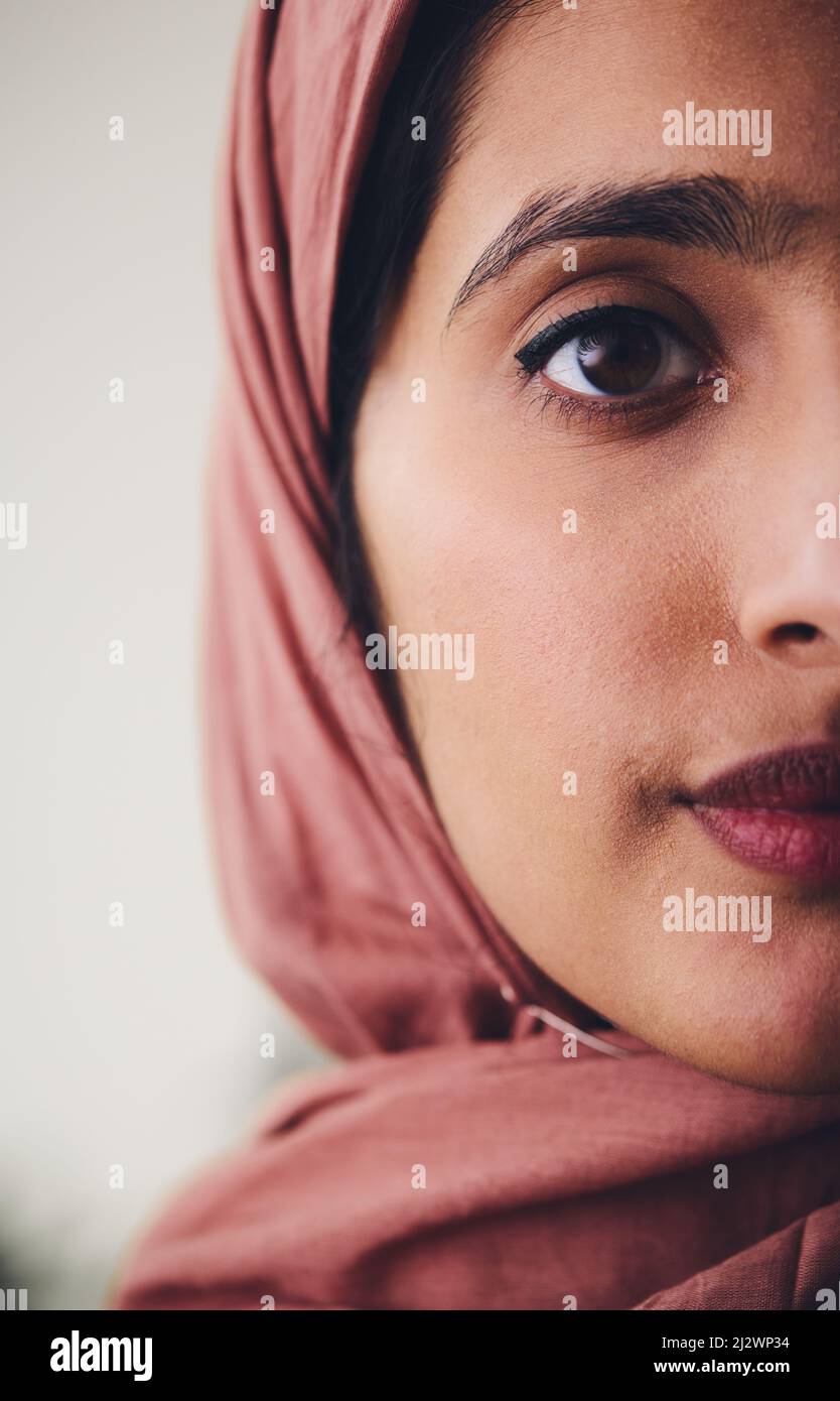 Cropped portrait of young Muslim woman wearing hijab looking towards camera with confident expression Stock Photo