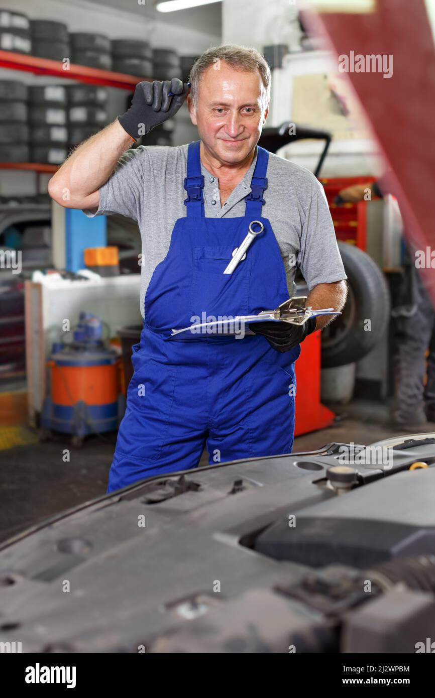 Car mechanic writing job sheet for repairs of vehicle Stock Photo Alamy