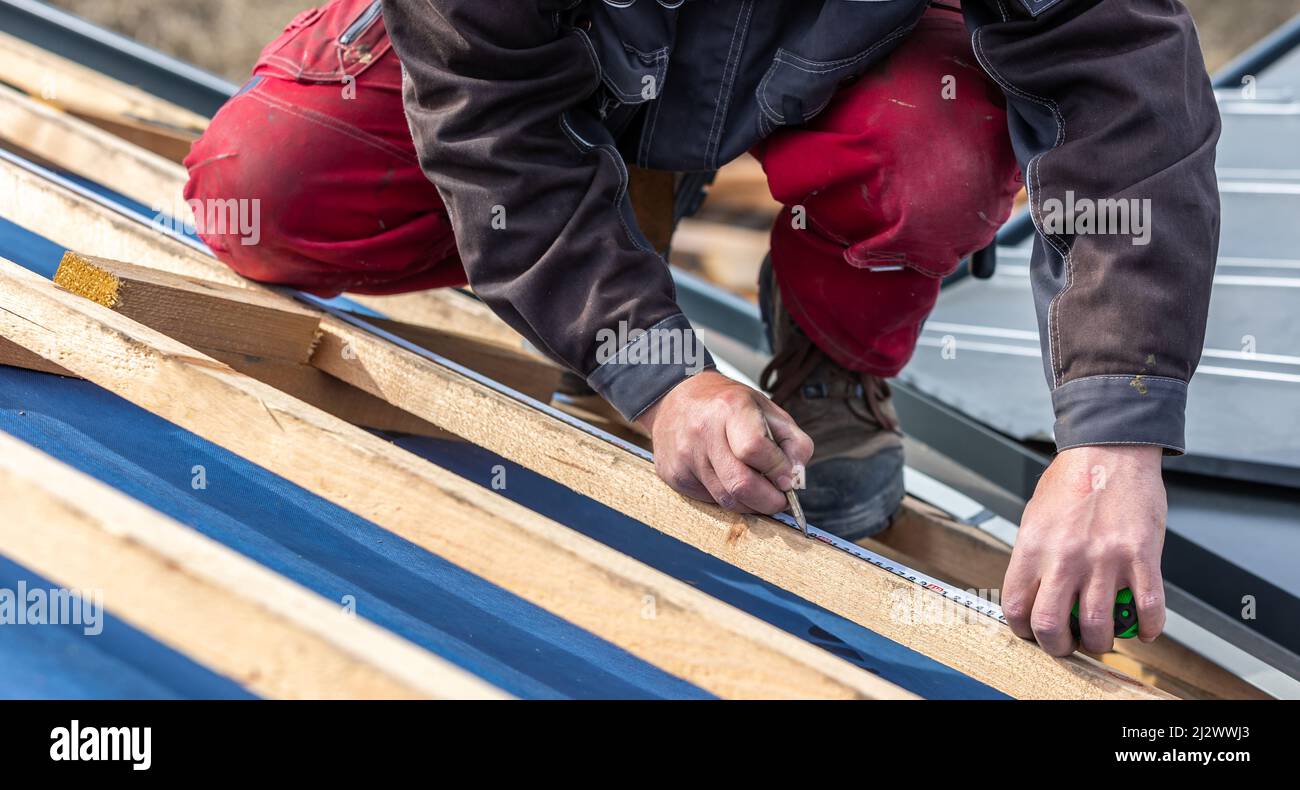 https://c8.alamy.com/comp/2J2WWJ3/craftsman-or-construction-worker-install-a-new-roof-roofing-tools-new-metallic-roof-or-metal-sheet-building-concept-2J2WWJ3.jpg
