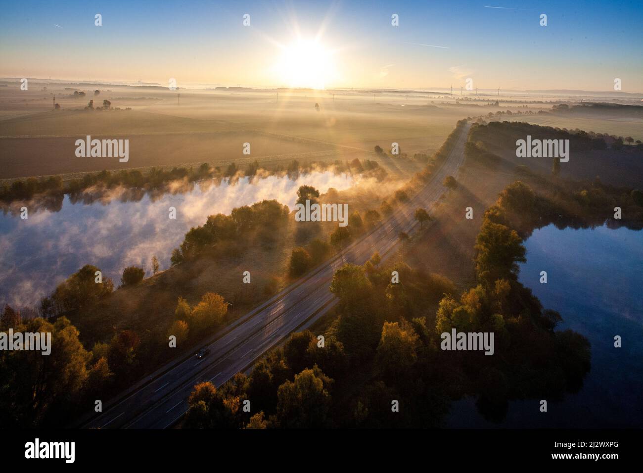 Morning landscape with lakes on the A7 near Hildesheim, back light, aerial view, sun on the horizon, German motorway, Stock Photo