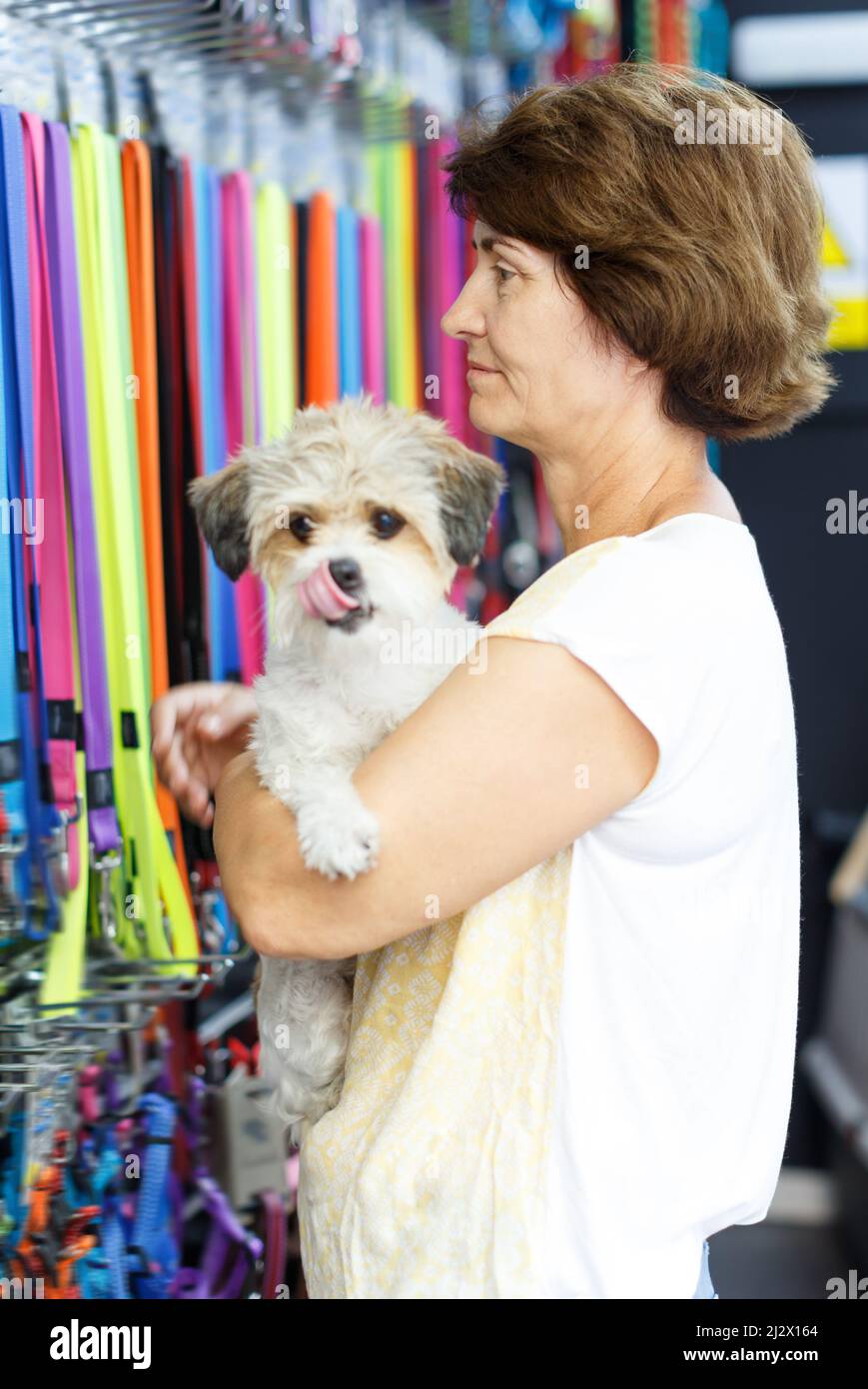 Mature woman visiting pet shop in search of accessories for her dog